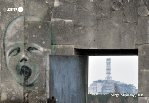 Graffiti à Pripyat, près de Tchernobyl (arrière plan) en avril 2011 - Sergei Supinsky - AFP