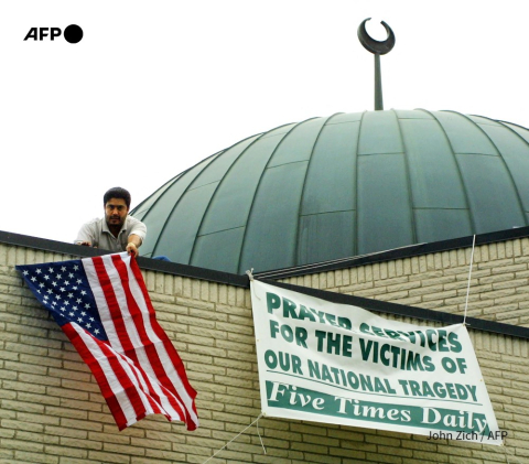 A man hangs a US flag from a Chicago mosque after 9/11 - John Zich - AFP