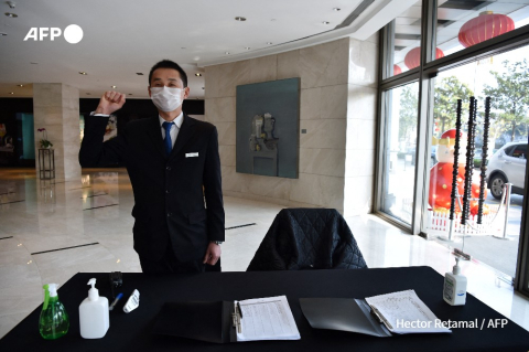 Employé chargé de prendre la température à l'hôtel Marco Polo de Wuhan - Hector Retamal - AFP