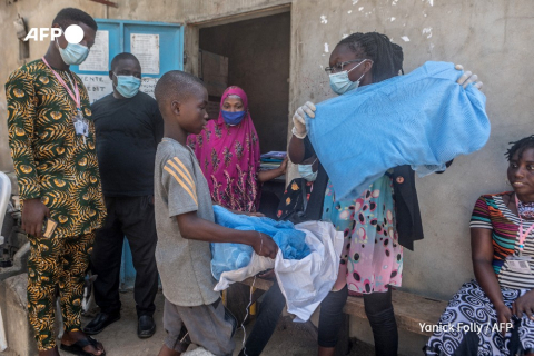 A boy receives anti-malaria mosquito net, 2020 - Yanick Folly - AFP