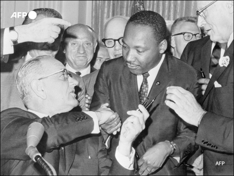 President Lyndon B. Johnson and Martin Luther King at the signing of the Civil Rights Act (1964) - AFP