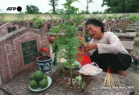 Nguyen Thi Xay, 64 ans, pleure sur la tombe de son fils dans un cimetière militaire près de Hanoï, le 26 juillet 1997 - Hoang Dinh Nam - AFP