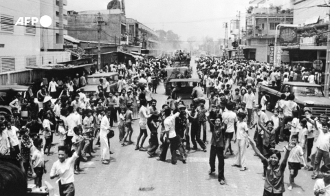 Des jeunes accueillent les forces nord-vietnamiennes entrées dans Saigon le 30 avril 1975 - AFP