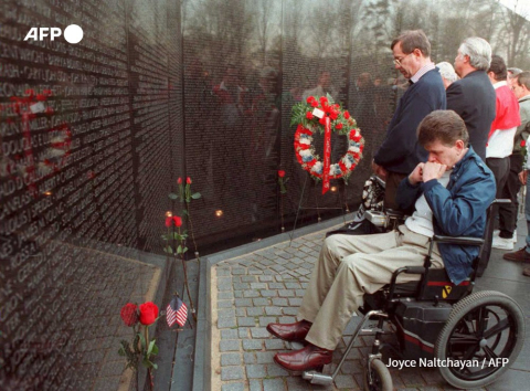 Un groupe de personnes se recueille devant le mémorial aux morts de la guerre du Vietnam, à Washington, le 8 avril 1995 - Joyce Naltchayan - AFP