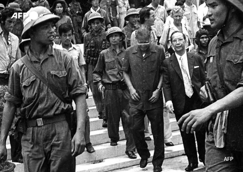 Duong Van Minh (C, looking down), the last president of South Vietnam, and his entourage leave the presidential palace in Saigon on April 30, 1975 - AFP