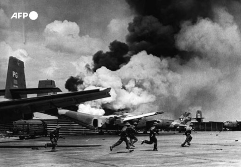 An April 30, 1975 photo shows North Vietnamese soldiers running past burning aircraft at Saigon's Tan Son Nhat airport. - AFP