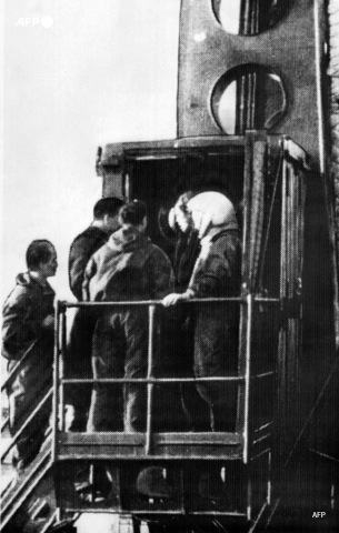 Le 12 avril 1961, Iouri Gagarine, déjà casqué et entouré de techniciens, s'apprête à pénétrer dans Vostok-1, à Baïkonour - AFP