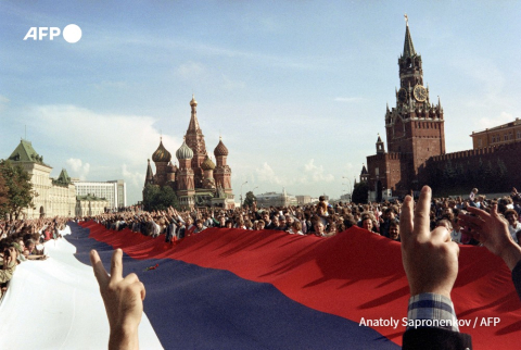 Le 22 août 1991, une foule de moscovites tenant un immense drapeau russe font des signes de victoire sur la Place Rouge à Moscou. - Anatoly Sapronenkov - AFP