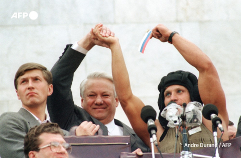 Le président russe Boris Eltsine serre la main d'un membre d'équipage de char tenant un drapeau russe, devant le parlement le 22 août 1991 à Moscou, alors que quelque 100.000 partisans célèbrent l'échec du putsch de trois jours contre Mikhaïl Gorbatchev. - André Durand - AFP