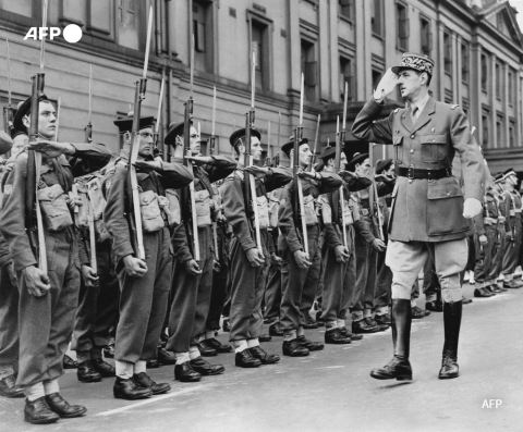 Photo prise en 1942 à Londres de Charles de Gaulle (D) passant en revue une unité des Forces françaises libres. - AFP