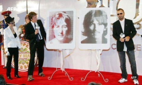 De G. à D., Yoko Ono-Lennon, Paul McCartney et Ringo Starr encadrent des portraits de John Lennon et George Harrison à Las Vegas, le 26 juin 2007 - AFP