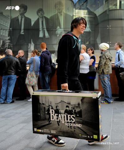 Un ado sort du magasin de disques HMV de Liverpool avec le nouveau jeu video interactif des Beatles Paul Ellis - AFP