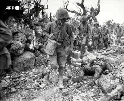 En avril 1945 des soldats américains patrouillent dans un village détruit lors de la bataille d'Okinawa - Norris G. Mcelroy - AFP