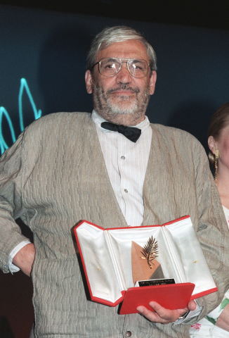 Le réalisateur français Maurice Pialat montre son prix sous les sifflets du public, le 19 mai 1987 au festival de Cannes, alors qu'il vient de remporter la Palme d'or pour son film Sous le soleil de Satan. CHRISTOPHE SIMON - AFP