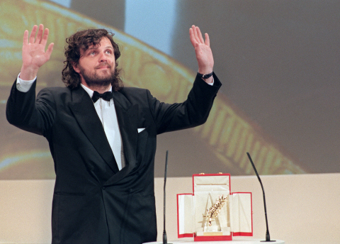 Emir Kusturica salue le public après avoir reçu la Palme d'or pour Underground, le 28 mai 1995 PATRICK HERTZOG - AFP