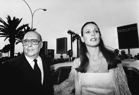 Roberto Rossellini entre au Palais des festivals au bras de l'actrice suisse Marthe Keller, membre du jury, le 01 mai 1977. - AFP