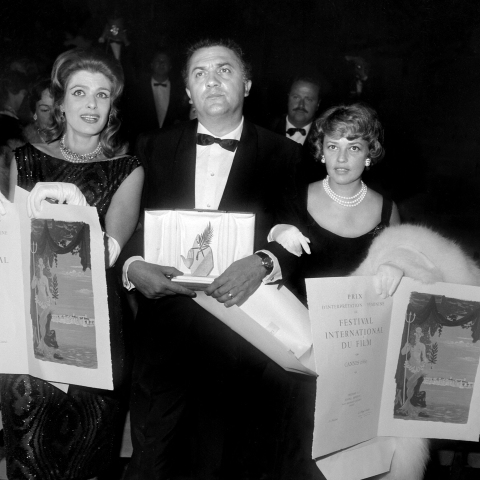 Federico Fellini pose avec la Palme d'or reçue pour La dolce vita, entouré de Melina Mercouri (G) et Jeanne Moreau (D) - AFP