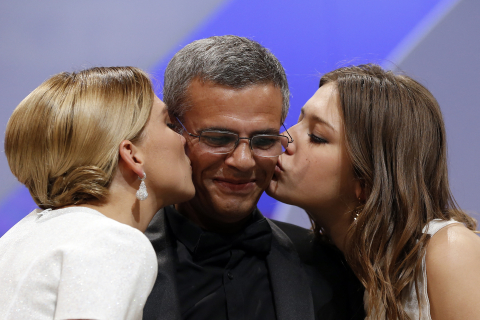 Léa Seydoux (G) et Adèle Exarchopoulos (D) embrassent le réalisateur Abdellatif Kechiche après avoir reçu la Palme d'Or pour La vie d'Adèle, le 26 mai 2013 VALERY HACHE - AFP