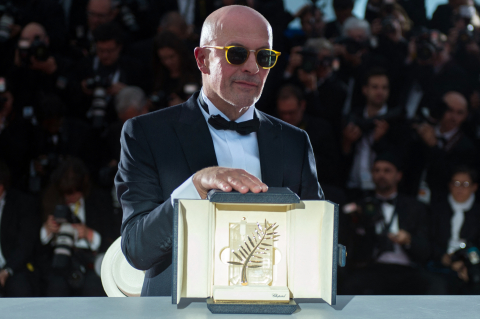 Le réalisateur Jacques Audiard pose avec la Palme d'or reçue pour Dheepan, le 24 mai 2015 BERTRAND LANGLOIS - AFP