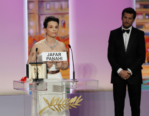L'actrice française Juliette Binoche brandit le nom du cinéaste Jafar Panahi après avoir reçu le prix de l'interprétation féminine pour Copie conforme, le 23 mai 2010 - François Guillot - AFP