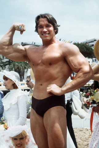 Arnold Schwarzenegger pose sur la plage pendant le 38e festival de Cannes le 19 mai 1977. - AFP