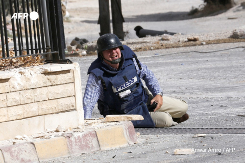 Le journaliste Sammy Ketz se protège d'un tir de sniper en Syrie en septembre 2013 - Anwar Amro - AFP