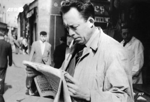 Photo d'Albert Camus (1913-1960), lisant un journal à Paris, prise en 1959 - AFP