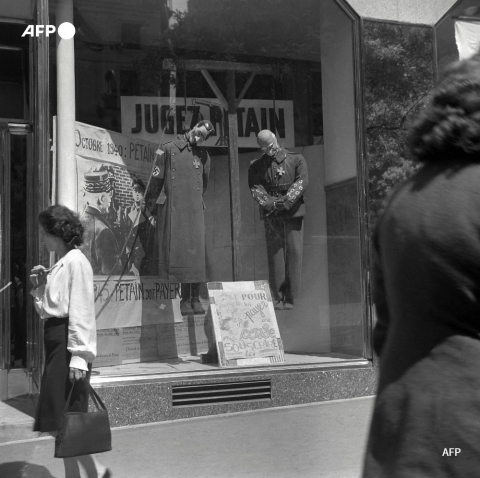 Des mannequins à l'effigie de Pétain et de Hitler sont pendus dans une vitrine, en mai 1945, à Paris - AFP