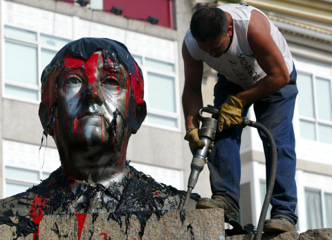 Un ouvrier s'emploie à démonter un buste de Franco installé sur la place principale du village de Ponteareas (nord) le 8 juillet 2003 Miguel Riopa - AFP