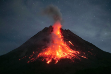 Le Mont Merapi, l'un des volcans les plus actifs d'Indonésie, crache de la lave lors d'une éruption, vue du hameau Dadap Ngori à Magelang, le 23 mai 2023. DEVI RAHMAN / AFP