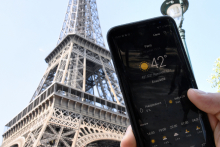 A person standing next to the Eiffel Tower holds a smartphone indicating a temperature of 42 degrees Celsius, on July 25, 2019 in Paris, as a new heatwave hits the French capital. - AFP 