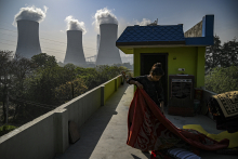 Sur cette photo prise le 6 avril 2022, une fille plie une couverture sur le toit de sa maison près de l'usine de la Thermal Power Corporation (NTPC) à Dadri. Prakash SINGH - AFP