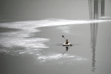 Un garçon fait avancer un bateau sur les eaux polluées de la rivière Yamuna chargées d'écume, par une chaude journée d'été à New Delhi, le 9 juin 2022.  Money SHARMA / AFP