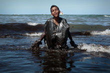 Le 21 octobre 2019, un adolescent, Everton Miguel dos Anjos, émerge de l’eau noirâtre sur la plage d’Itapuama, à Cabo de Santo Agostinho, avec le torse recouvert d'un grand sac en plastique maculé de pétrole. Dans son regard : l’accablement. Ce garçon de 13 ans, voulait juste aider sa mère, Ivaneide Maria de Oliveira, propriétaire d’une gargote sur la plage. © LEO MALAFAIA / AFP